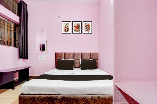 a bedroom with a bed in a room with pink walls at SPOT ON Hotel Shivansh in Bhilai