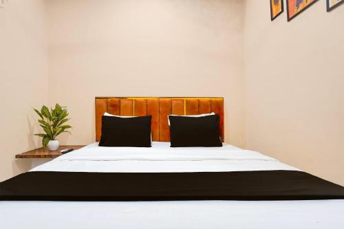 a bedroom with a large bed with black pillows at Hotel O Eden Stay in Bilāspur