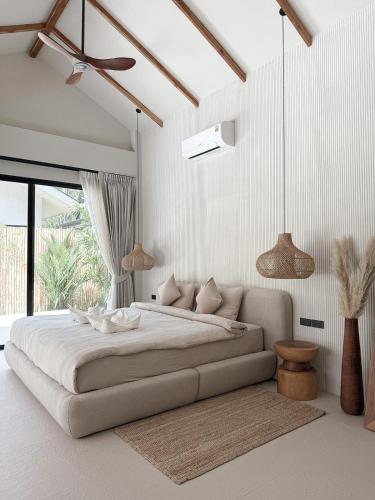 a white bedroom with a large bed and a window at K Villas Phangan 03 in Ko Phangan