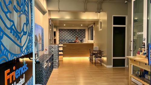 a hallway of a store with a bar in the background at Friends Hostel - Phuket Airport in Nai Yang Beach