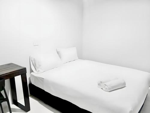a white bed in a room with a table at Oh My Nap Khaosan Road - ถนนข้าวสาร in Bangkok