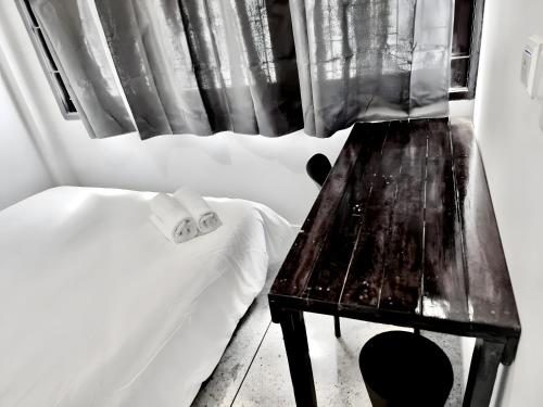 a room with a table and a bed and a window at Mitr Inn Khaosan Road - มิตรอินน์ ถนน ข้าวสาร xPro in Bangkok