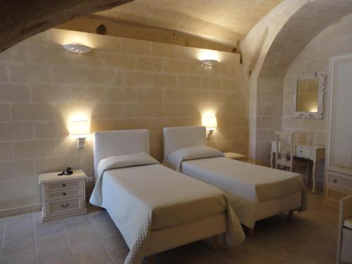 a bedroom with two beds and a dresser and lights at Caveoso Hotel in Matera