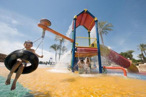 a young boy in a tire swing in the water at a water park at Jolie Ville Hotel & Spa Kings Island Luxor in Luxor