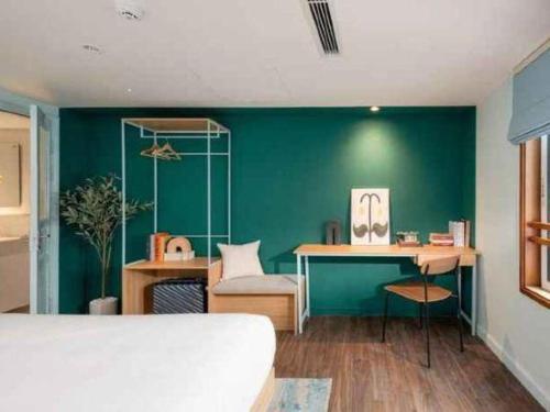 a bedroom with a bed and a green wall at Lenid De Ho Guom Hotel in Hanoi