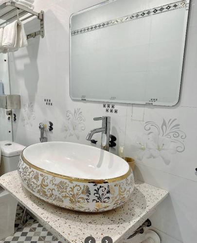 a bathroom with a sink and a mirror at SƠN NGUYÊN Hotel in Tràng Kinh