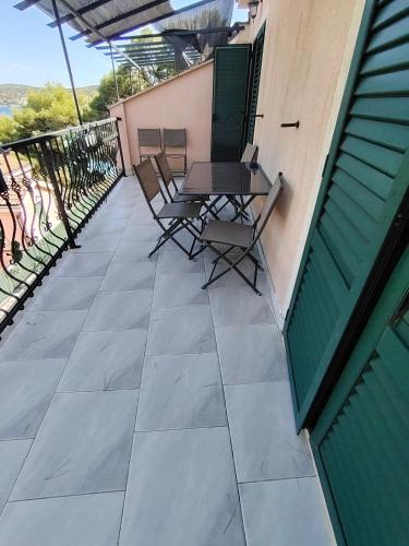 a patio with a table and chairs on a building at Kopara apartmanok in Rogoznica
