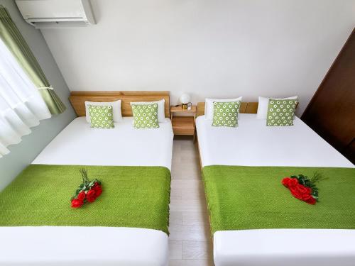 two beds in a room with red roses on them at 303Room,Tokyo Koiwa 6min Walk to Station 1BR Apartment for up to 4 Guests in Tokyo