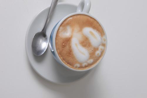 a cup of coffee on a plate with a spoon at Casterbridge Hollow Boutique Hotel in White River
