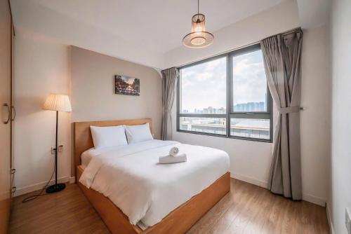 a bedroom with a large bed and a large window at The Vista Masteri Thao Dien N-Stay Apartment in Ho Chi Minh City