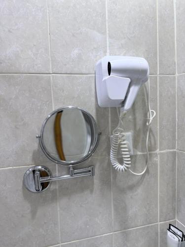 a mirror and a phone on a wall at Elaf Al bait ايلاف البيت in Mecca