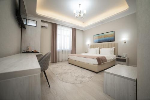 a hotel room with a bed and a desk at Turon Lux Hotel in Samarkand