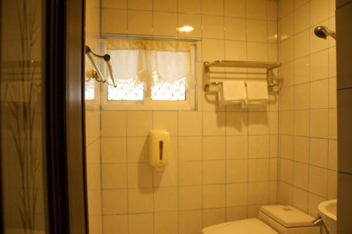 a bathroom with a toilet and a window at 文風小築Wen-Feng House-免費停車 in Kenting