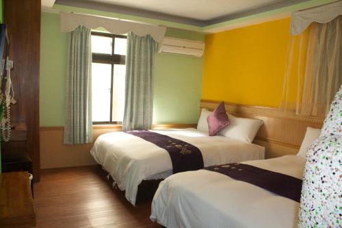 two beds in a room with yellow and green walls at 文風小築Wen-Feng House-免費停車 in Kenting