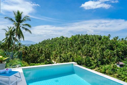 a swimming pool with a view of a forest at Villa Melo in Chaweng Noi Beach