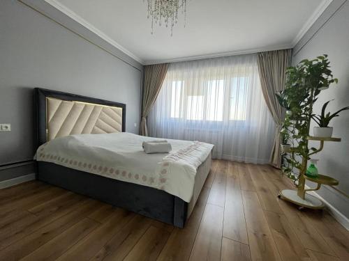 a bedroom with a large bed and a potted plant at Ush Sunkar Best in Almaty in Almaty