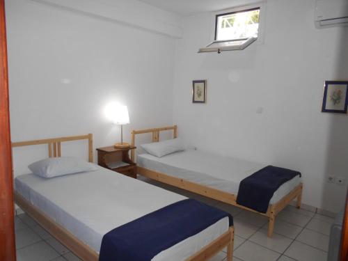 a room with two beds and a window at Periyali in Keratea