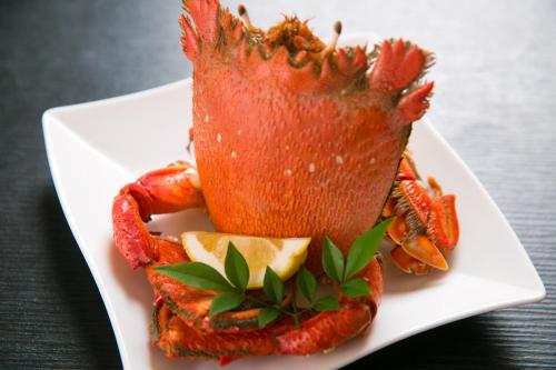 a lobster on a white plate on a table at Tashiro Annex in Yakushima
