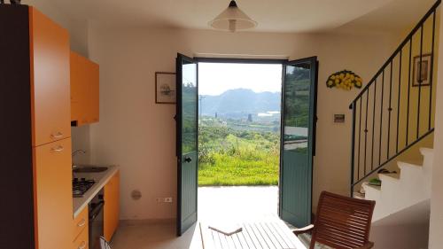 een keuken met een glazen schuifdeur met uitzicht bij Rio Rosa in Bova Marina