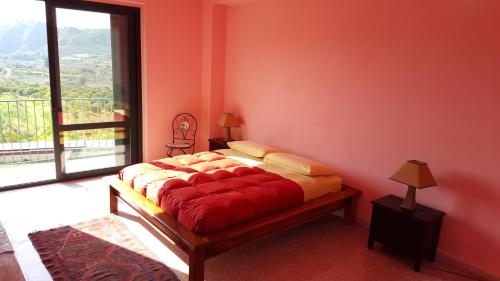 ein Bett in einem Zimmer mit einem großen Fenster in der Unterkunft Rio Rosa in Bova Marina