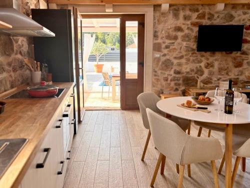 a kitchen with a table and chairs and a dining room at Casa Rustivéra - Island Hvar in Vrbanj
