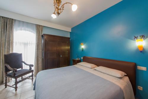 a bedroom with blue walls and a bed and a chair at B&B Casa Roman & Vakantiewoning voor 1 pers tot max 32 personen in Zonhoven
