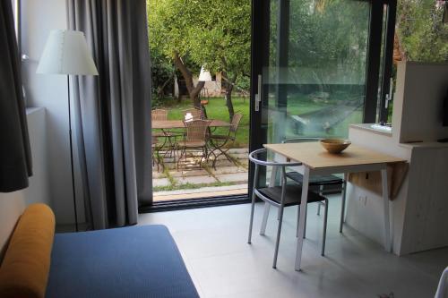 um quarto com uma mesa e cadeiras e uma porta de vidro deslizante em Nel Giardino degli Agrumi em Palermo