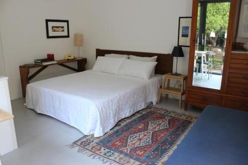 um quarto com uma cama branca e um tapete em Nel Giardino degli Agrumi em Palermo