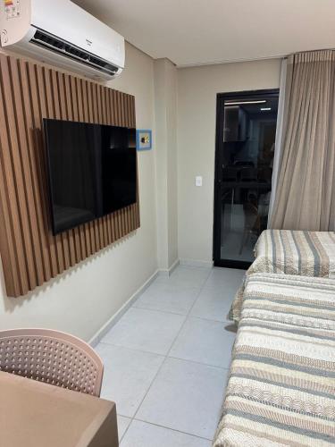 een woonkamer met een flatscreen-tv aan de muur bij Flat Varandas do Porto Residence in Porto De Galinhas