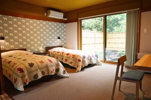 a bedroom with two beds and a window at Furusato in Takayama