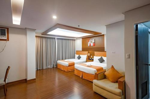 a hotel room with two beds and a couch at Subic Grand Harbour Hotel Subic Bay in Olongapo