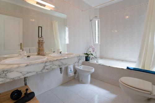 a bathroom with two sinks and a tub and a toilet at Villa Pippa in Puerto del Carmen