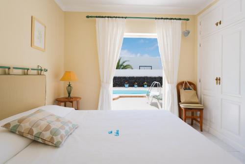 a bedroom with a bed and a view of a pool at Villa Pippa in Puerto del Carmen