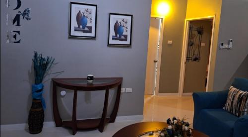 a living room with a table and a blue couch at The KenEdrice in Kupuis