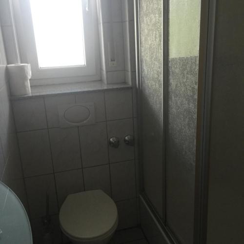 a bathroom with a toilet and a window and a shower at Gasthaus Keglerklause in Schwieberdingen
