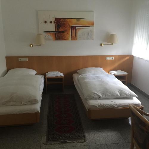 a room with two beds and two tables at Gasthaus Keglerklause in Schwieberdingen