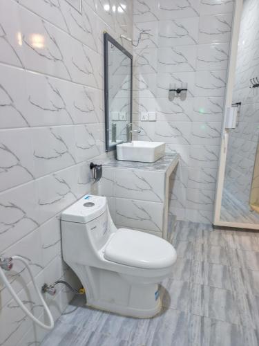 a white bathroom with a toilet and a sink at Zanzibar Luxury Bungalows in Tongoni