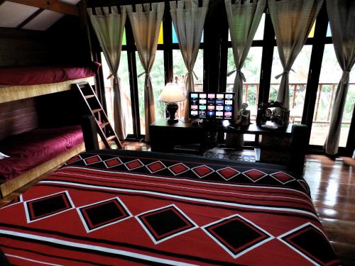a bedroom with a bed and a desk with a lamp at Rice Barn And Rooms in Hang Dong