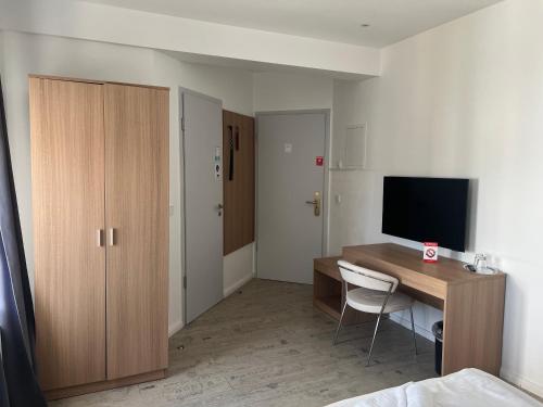 プットブスにあるBed & Breakfast am Schlossparkのテレビとベッドのある机のある部屋