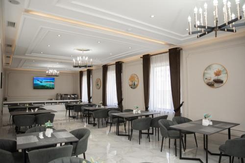 a restaurant with tables and chairs in a room at Turon Lux Hotel in Samarkand