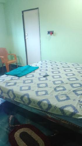 a bed with a comforter on top of it at Arnav Lodge & Restaurant in Jhārsuguda