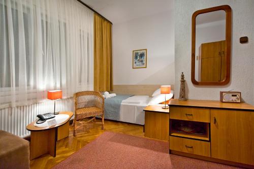 a hotel room with a bed and a mirror at Dom Wypoczynkowy Helunia in Jurata