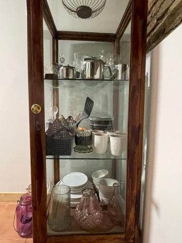 a glass cabinet filled with dishes and utensils at Terracotta in Tʼelavi