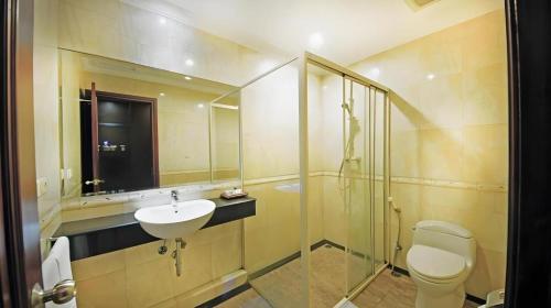 a bathroom with a toilet and a sink and a shower at Tematik Hotel Pluit in Jakarta