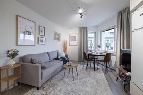 a living room with a couch and a table at RIVER VIEW CITY NEST - Nordic Apartment With Views in Rovaniemi