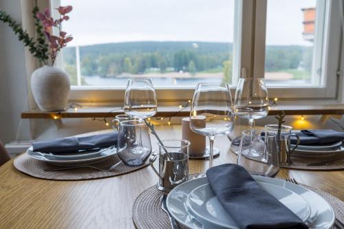 a table with plates and wine glasses on it at RIVER VIEW CITY NEST - Nordic Apartment With Views in Rovaniemi