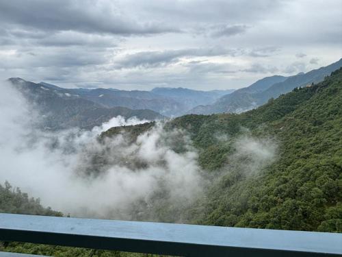 - une vue sur une montagne aux nuages dans la vallée dans l'établissement The Happy Land Mussoorie, à Mussoorie