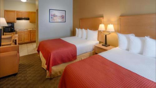 a hotel room with two beds and a kitchen at Best Western Plus Guymon Hotel and Suites in Guymon