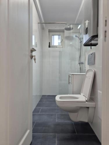 a white bathroom with a toilet and a sink at D&D Central Apartment in Tulcea