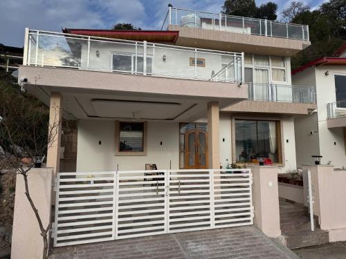 a house with a white fence in front of it at Monal by Shubhs in Bhowāli